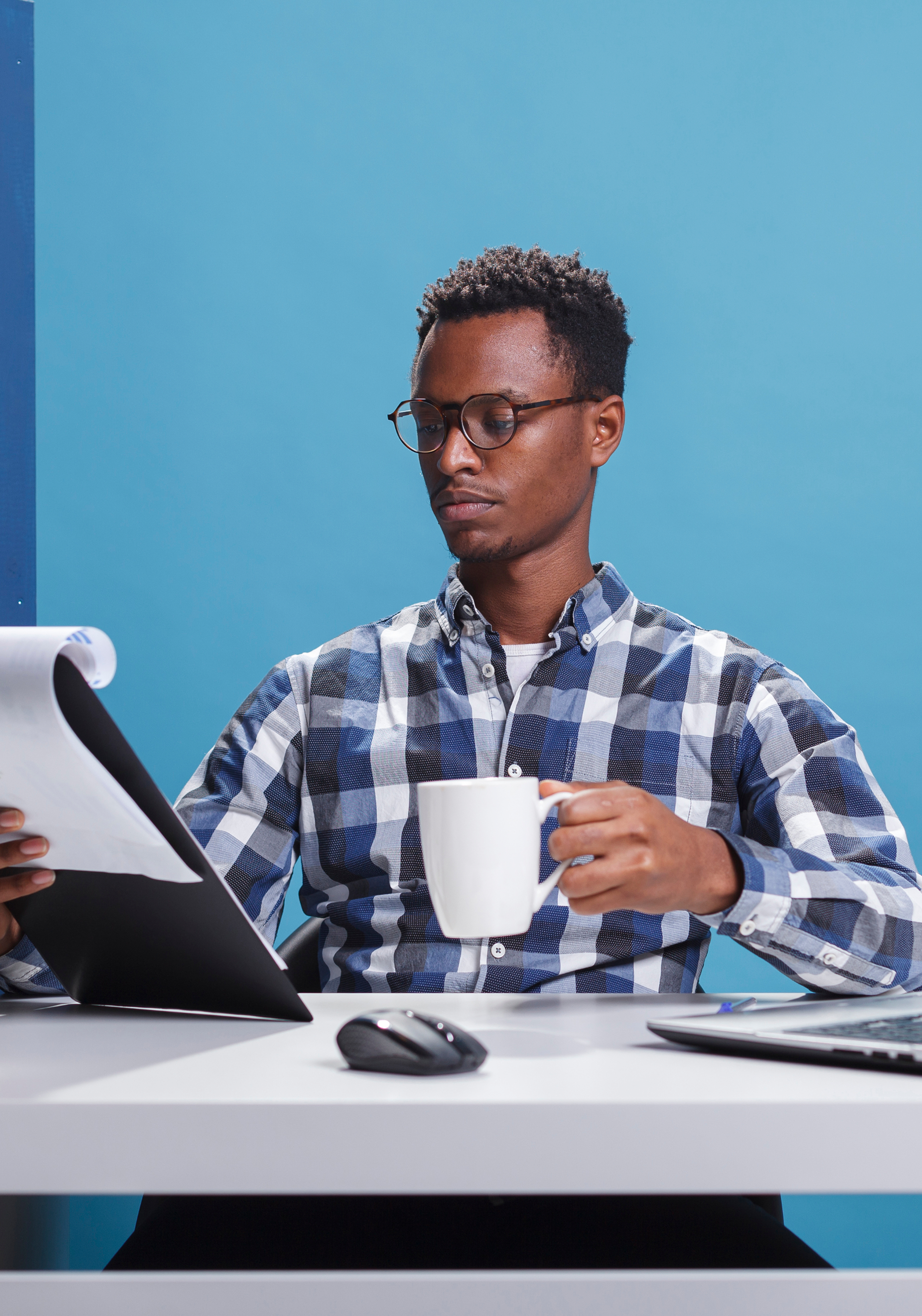 Employee Sitting at Modern Workspace Reviewing Paperwork